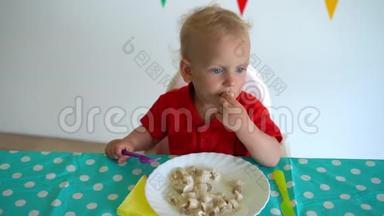 小男孩用叉子吃饺子，用另一只手挨着桌子。 万向节运动